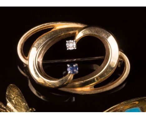 Three 9ct gold brooches, one open scroll brooch set with a single diamond and sapphire, imported London 1979; one of bi-disc 