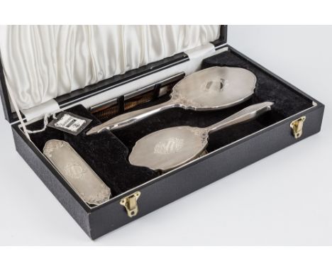 A cased Elizabeth II silver mounted dressing set, W. I. Broadway & Co., Birmingham 1978, comprising hand mirror, two brushes 