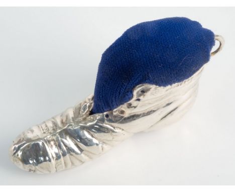 An Edwardian silver novelty boot pin cushion, Samuel M Levi, Chester 1910, modelled as an untied old leather boot with metal 