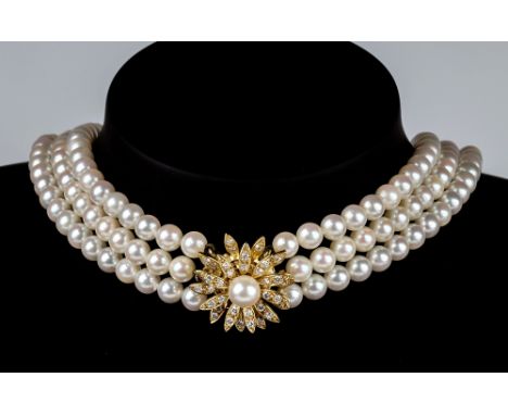 A three row cultured pearl choker with diamond clasp, the three rows of 5mm. pearls with a diamond and pearl set 18ct gold fl