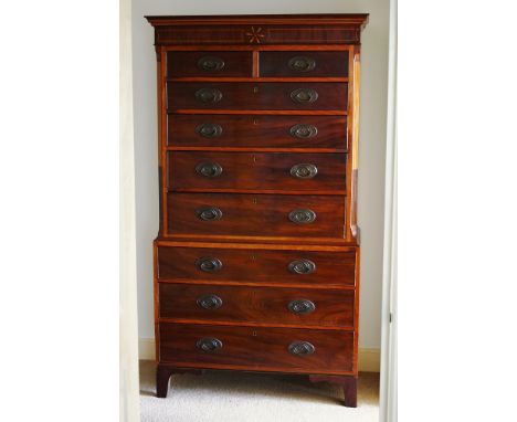 An early 19th century inlaid satinwood and mahogany chest on chest, the flared, ebony and satinwood banded cornice over a box