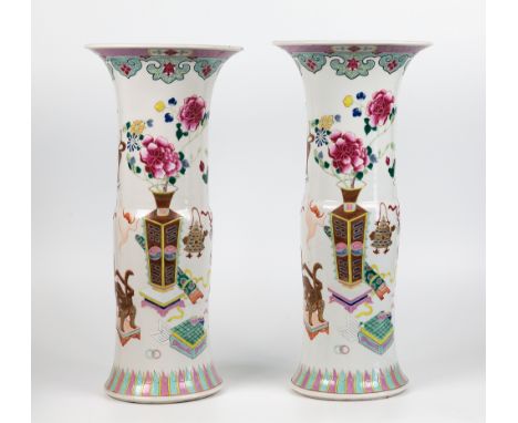 A pair of Chinese porcelain famille rose beaker vases, 19th century, cylindrical form with accented central waist, flared eve