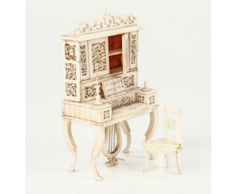 A 19th century carved ivory and bone miniature pianola cabinet and chair, French or Indian, the pianola on four inswept conca