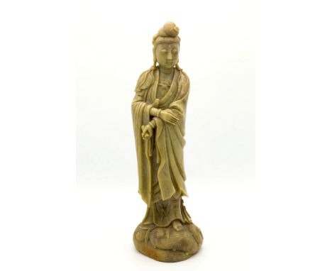 A Chinese carved soapstone figure of Guanyin, upright robed figure holding a scroll in her right upon crested waves, 14¼in. (