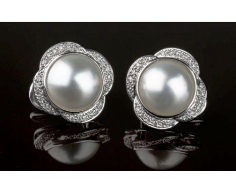 A pair of 18ct white gold, Mabé pearl and diamond flower earrings, the 13mm. pearls within shaped 'petal' borders set with sm