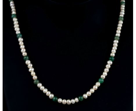 A 1920s-30s seed pearl and jade style necklace, the single stand of 3-4mm. seed pearls spaced at intervals with green jade st