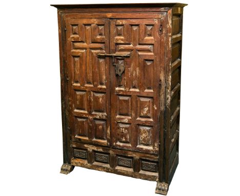 An 18th century Spanish walnut two door cupboard, the flared moulded cornice over a pair of cruciform and multi-rectangular p