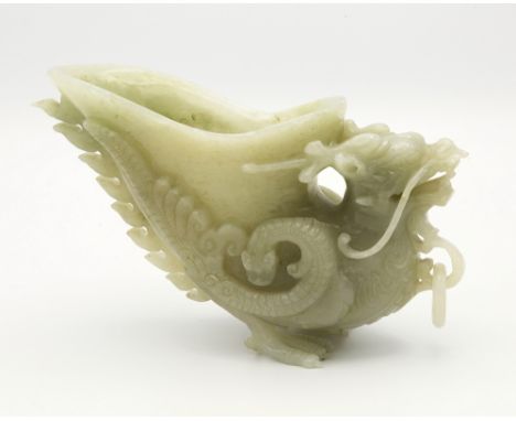 A Chinese carved jade dragon libation cup, 20th century, hollow vessel held between wings of dragon's back, ring handle to fr