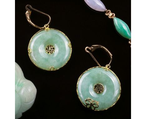 A pair of 14ct gold and jade earrings, the mottled, celadon jade discs with gold rim mounts and central pierced gold characte
