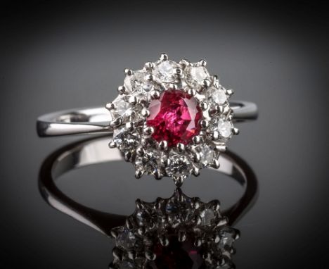 An 18ct white gold, ruby and diamond cluster ring, the central round cut ruby within a border of ten brilliant cut diamonds, 