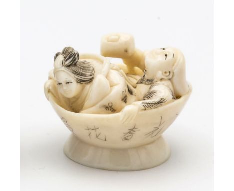 A Japanese carved ivory netsuke, first half 20th century, of two figures in a large bowl, one looking aloft and holding a mal