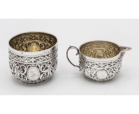 A Victorian Scottish silver part bachelor set - sugar bowl and cream jug, Edinburgh 1883, J. R. & S, heavily embossed with bi