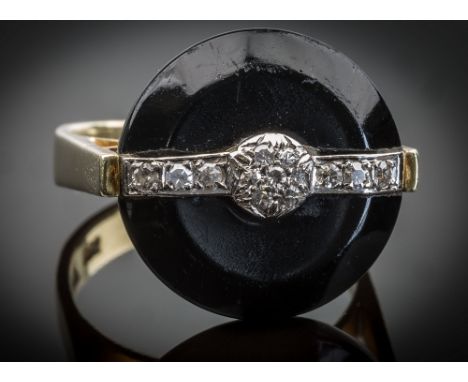 An Art Deco style 14ct yellow gold, black glass and diamond ring, the bevelled, button form black glass beneath a diamond set
