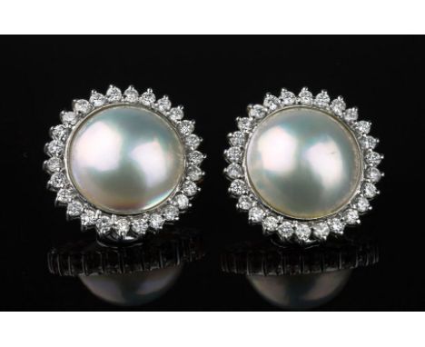 A pair of 18ct white gold, Mabé pearl and diamond cluster earrings, the 13mm. pearls within a border of twenty six brilliant 