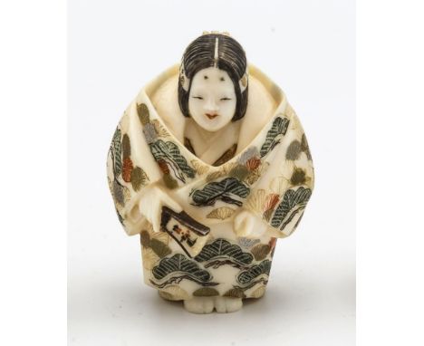 A Japanese carved ivory netsuke, Meiji period (1868-1912), depicting a female Noh actress in polychrome decorated robes, hold