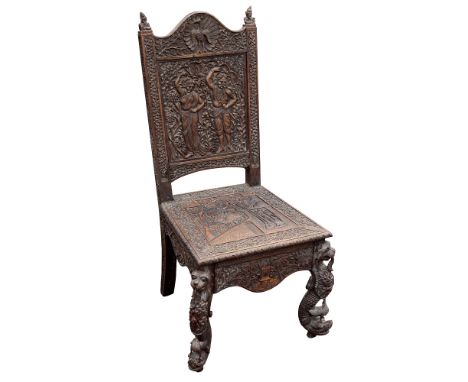 A profusely carved Anglo-Indian hardwood side chair, circa 1860, Bombay region, arched top rail with centralised peacock to f