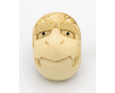 A Japanese carved ivory netsuke of a Tengu mask, Meiji period (1868-1912), with ebony inlaid eyes, unsigned, 2in. (5.1cm.) lo