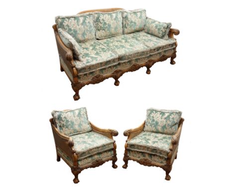 Early 20th century walnut framed bergere suite, the acanthus carved outsplayed arms with double caned sides, scroll and leaf 