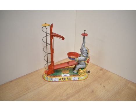 A mid 20th century US Zone Germany tin plate and clockwork Elephant with helta skelter, missing ball, and decoration to top o