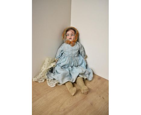 An early 20th century GOSS bisque headed doll having fixed open eyes and mouth, cloth stitched body with bisque hands and arm