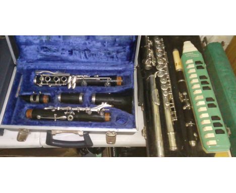 Assorted musical instruments comprising a clarinet, a silver plated flute, a rosewood piccolo and a recorder.  