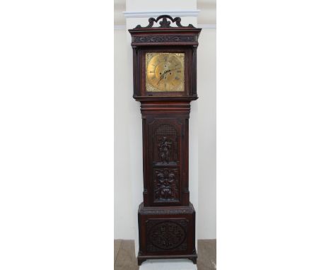 A 19th century carved oak longcase clock, the hood with a carved cresting rail above a long trunk door carved with a figure a