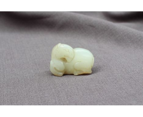 A Chinese "mutton fat" jade carving of a recumbent horse, 4cm long x 3cm high 