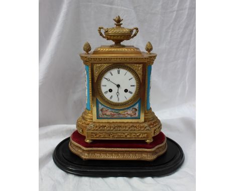 A 19th century French ormolu and porcelain clock, with a vase and pineapple finials, above an egg and dart frieze, the enamel