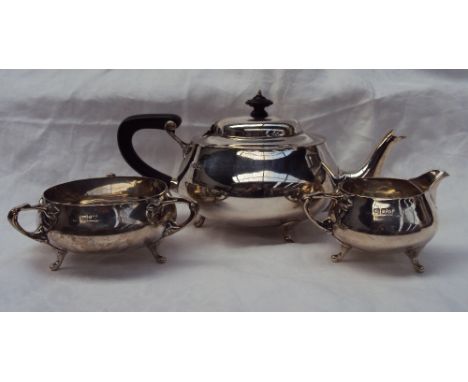 A George V silver three piece tea set, comprising a teapot, cream jug and three handled sugar basin, with naturalistic handle