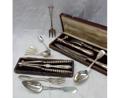 A French white metal carving set, comprising knife, fork and bone holder, cased together with white metal table spoons, table