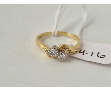 A two stone diamond cross over ring with diamond set shoulders 0.31 carat 18ct gold size M 3.2 gms