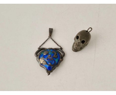 A silver and enamel pendant and a soap stone skull charm