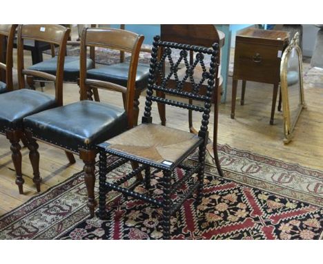 A Victorian ebonised bobbin-turned chair, with lozenge back splat, rush seat, the legs joined by stretchers.