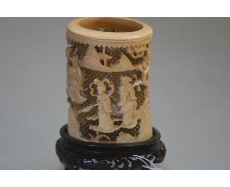 A Chinese tusk section ivory brush pot, Canton, 19th century, carved in relief with ladies in a mountainous landscape against