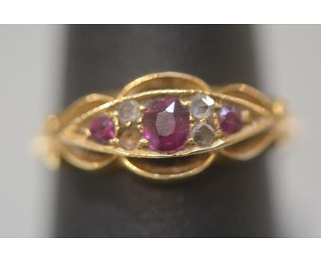 A ruby and diamond ring, early 20th century, centred by an oval cut ruby flanked by a pair of round-cut rubies spaced by pair