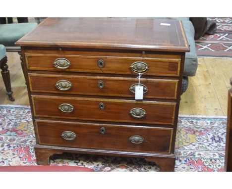 A small George III inlaid mahogany chest of drawers, the rectangular top with a band of satinwood inlay above a brushing slid
