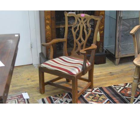 An oak child's armchair in the Chippendale taste, c. 1900, with yoke crest rail and pierced splat, drop in seat flanked by ou