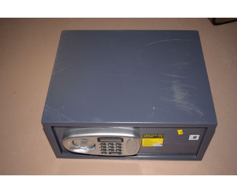 A modern digital home safe, with electronic code, manual keys and instruction sheet.