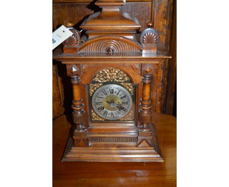 A 19th Century chiming mantel clock in ornate architectural style mahogany case, the circular silvered roman dial surrounded 