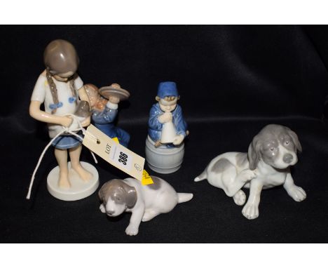 A Danish ceramic figure modelled as a girl carrying a kitten; a Royal Copenhagen figure of a child with symbols, no. 3699; an
