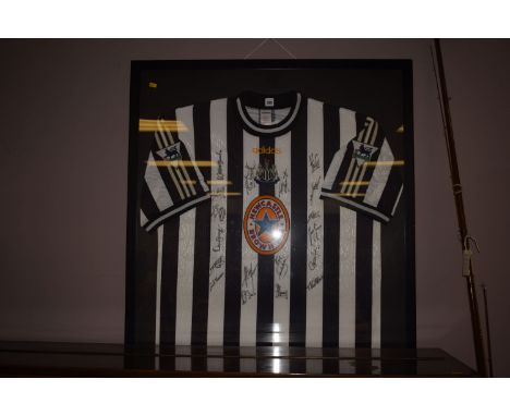 A Newcastle United replica football shirt, signed by the squad, c.1997-98 season, framed.