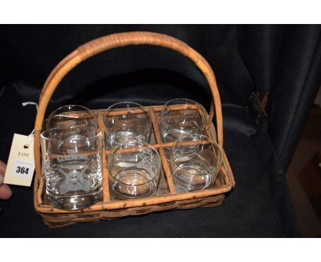 A wicker basket containing six whisky glasses, engraved 'Claymore Scotch Whisky'.