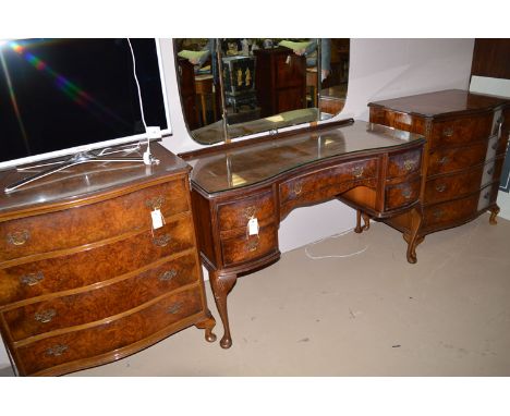 A pair of reproduction figured walnut serpentine front chests of four graduating drawers with ornate brass handles, raised on