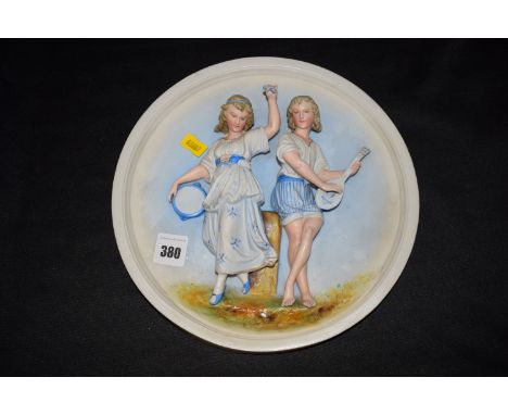 A circular Continental ceramic wall plaque depicting two girls with musical instruments, impressed mark in blue to the revers