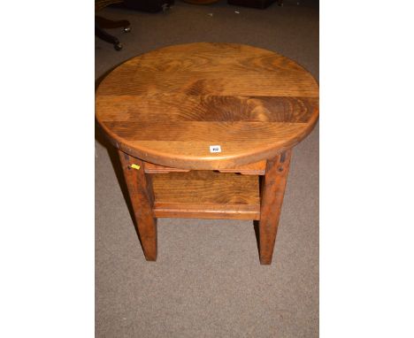 A modern circular stained pine two-tier occasional table, raised on tapering legs.