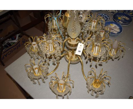 A modern twelve-branch metal chandelier with glass lustre drops.