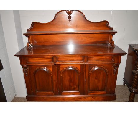 A reproduction mahogany Victorian style chiffonier, with shaped back with carved decoration, with a shelf on ornate bracket, 