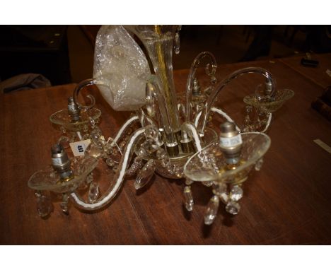 A five-branch glass chandelier with lustre drops.