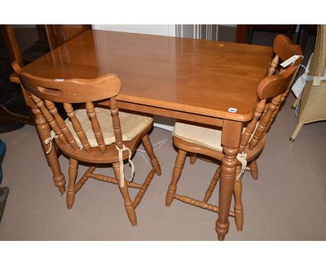 A modern rectangular stained wood Victorian style kitchen table; together with two matching solid seat dining chairs with spi