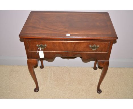 A reproduction inlaid mahogany lowboy table with moulded edge, fitted a single drawer in one side frieze, raised on cabriole 